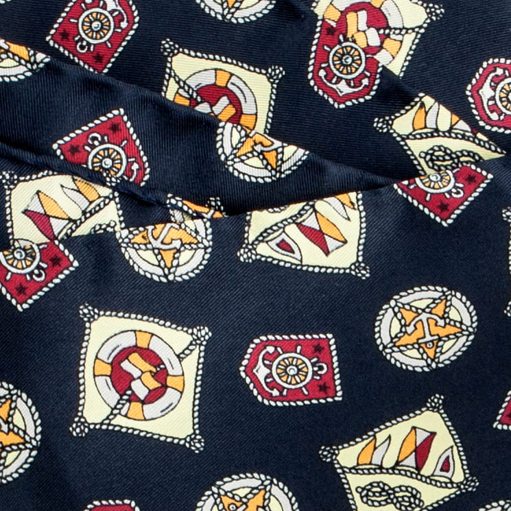 Navy blue silk pocket square with a maroon and yellow nautical pattern