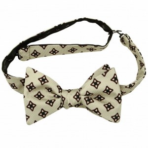 Handcrafted bow tie made from light beige printed silk with a geometric floral pattern