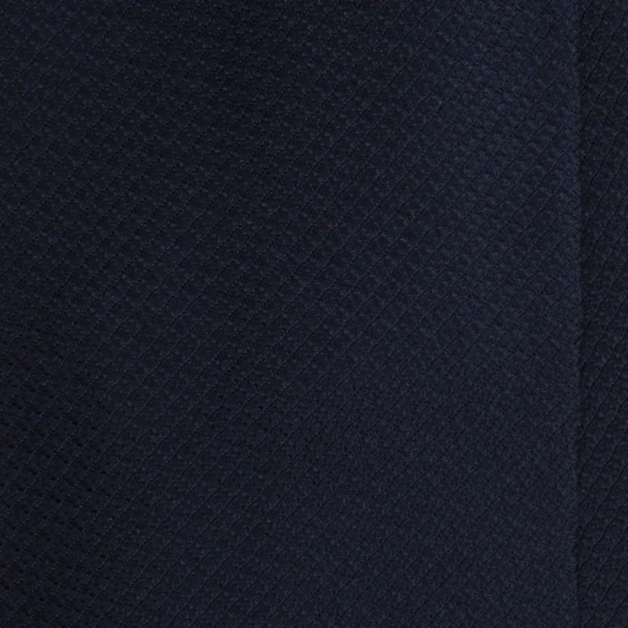 A close-up of a dark navy blue silk jacquard tie with a fine weave