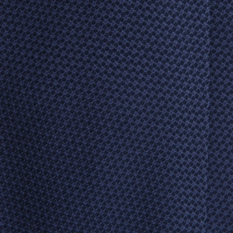 A close-up of a navy blue silk jacquard tie with a fine weave