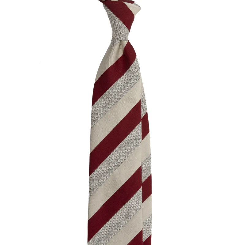 A red silk jacquard tie in cream stripes with a herringbone band, tied in a knot