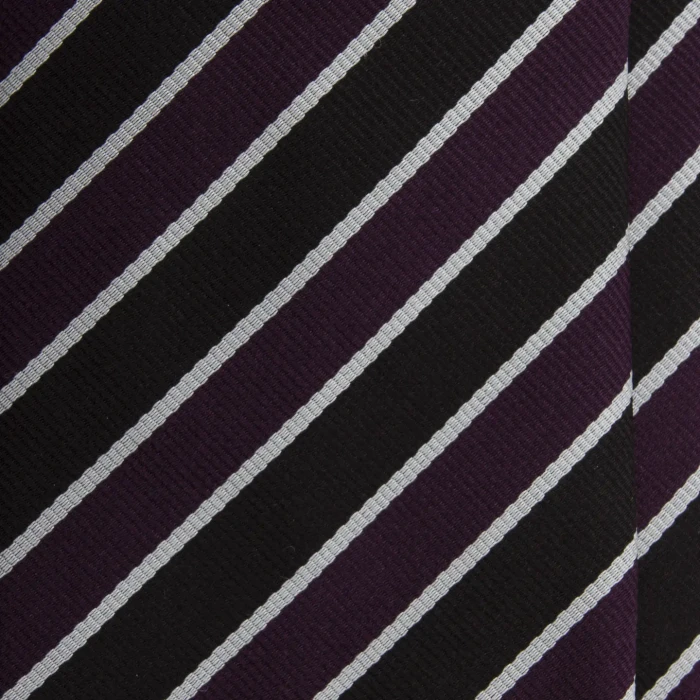 A close-up of a black and purple silk jacquard tie with silver pinstripes