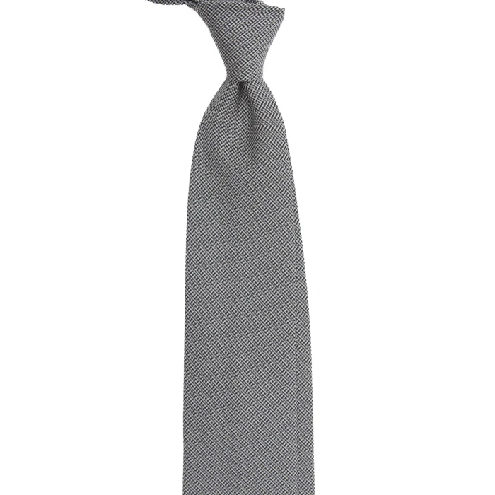 A black and white silk jacquard tie in fine houndstooth, tied in a knot