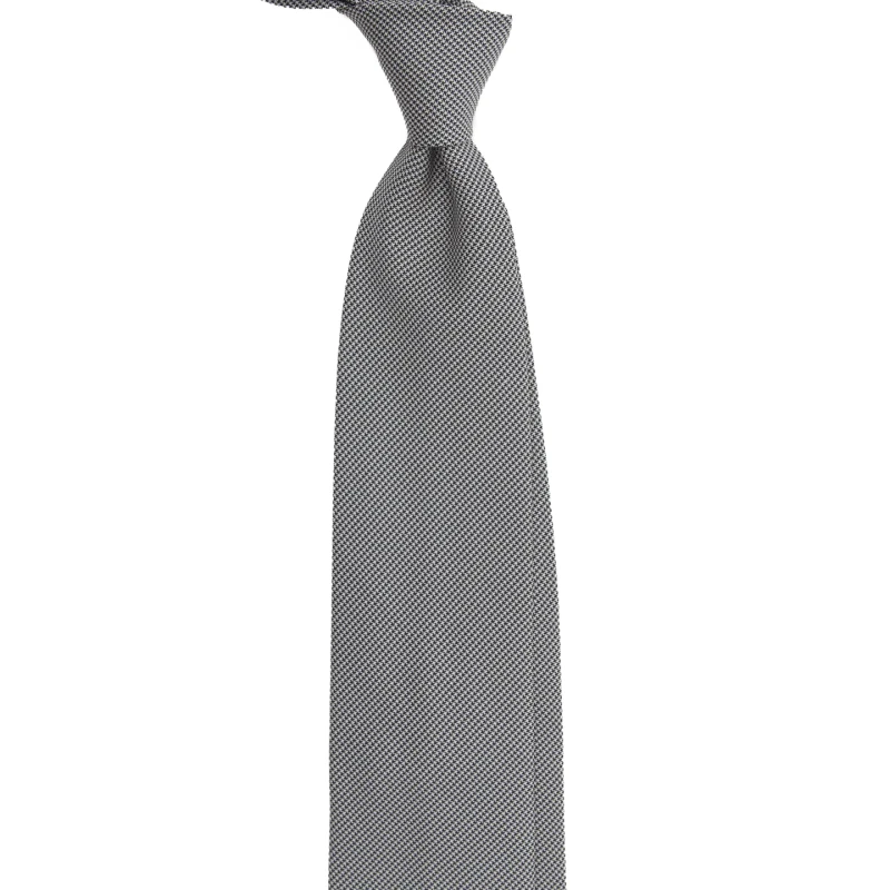A black and white silk jacquard tie in fine houndstooth, tied in a knot