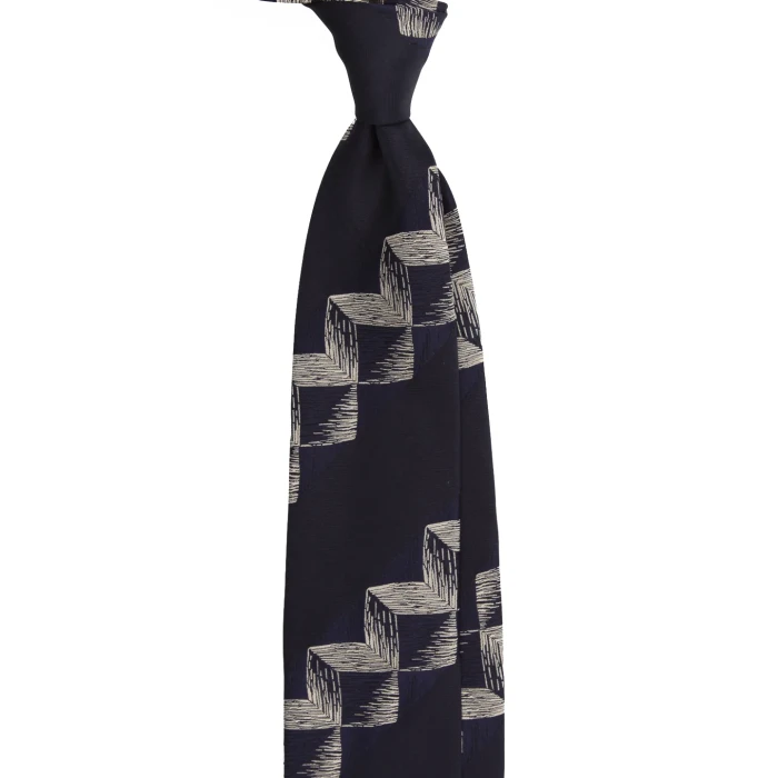 A navy silk jacquard tie with a geometric pattern, tied in a knot