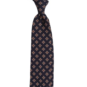 A navy silk tie with floral medallions, tied in a knot