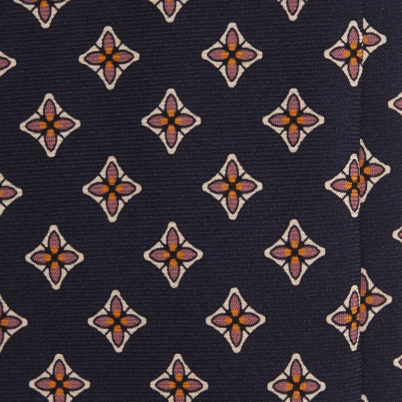 A close-up of a navy silk tie with floral medallions