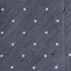 A close-up of a grey-blue silk jacquard tie with white polka dots