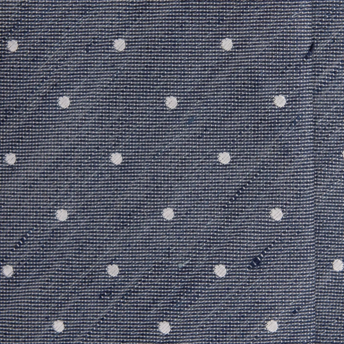 A close-up of a grey-blue silk jacquard tie with white polka dots