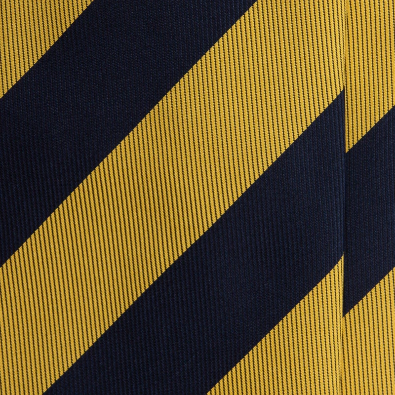 A close-up of a navy silk jacquard tie in wide mustard stripes