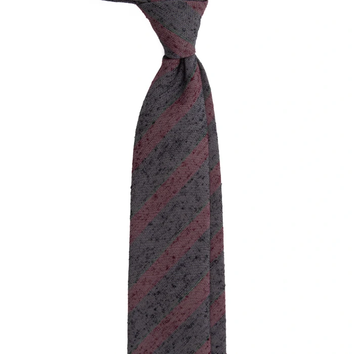 A grey silk tie with plum stripes in a textured weave, tied in a knot