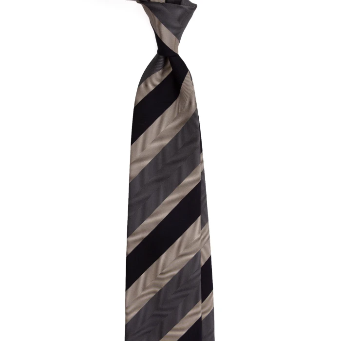 A black and grey silk jacquard tie in wide beige stripes, tied in a knot
