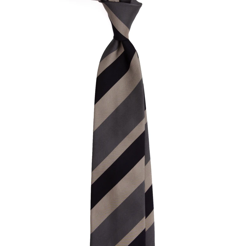 A black and grey silk jacquard tie in wide beige stripes, tied in a knot
