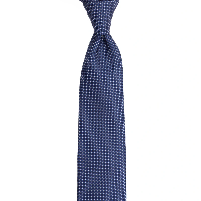 A navy silk jacquard tie with a micro pattern, tied in a knot