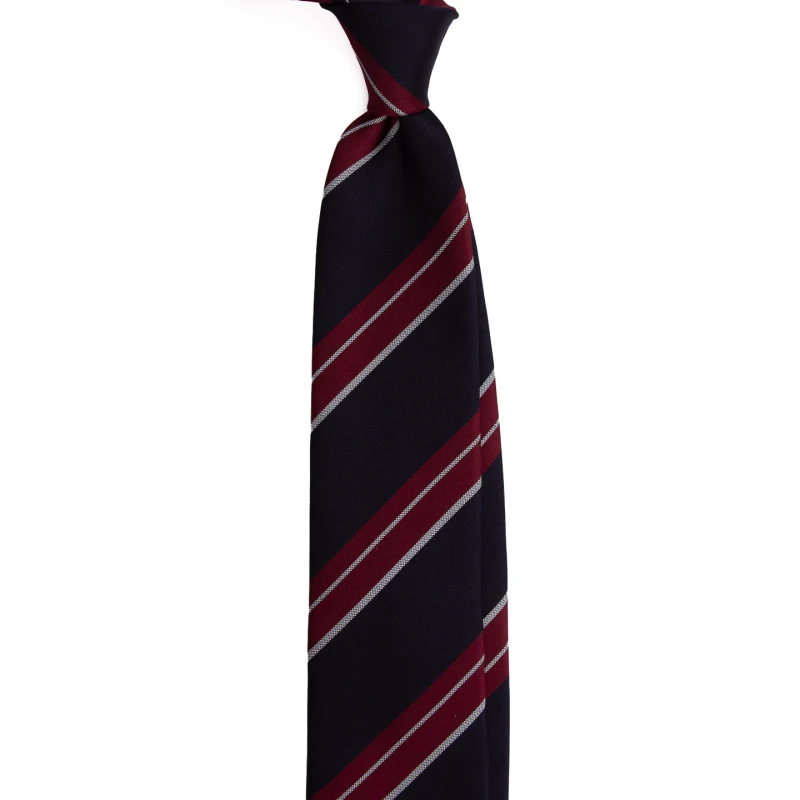 A navy silk jacquard tie with burgundy stripes, tied in a knot