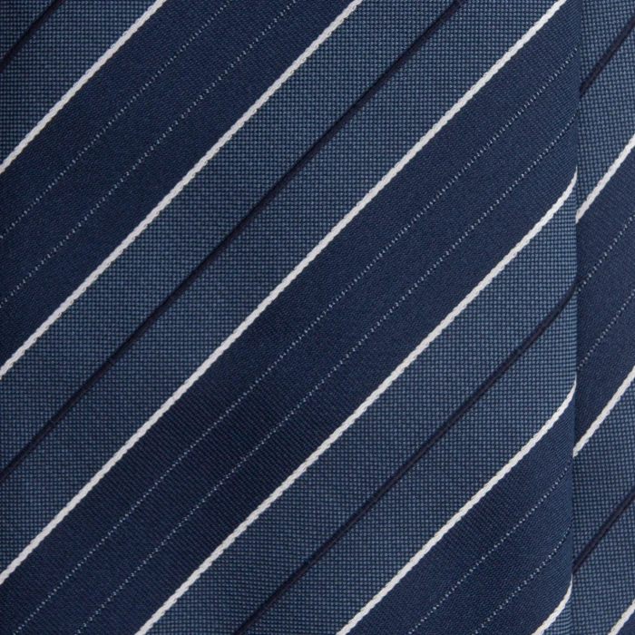 A close-up of a navy silk jacquard tie with steel blue stripes and white pinstripes