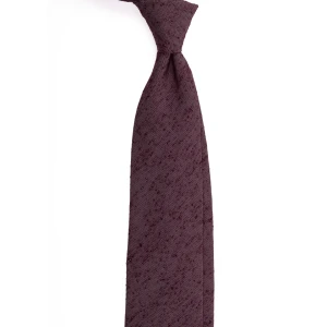 A plum silk tie in a textured weave, tied in a knot